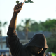 FILE - In this March 22, 2012 file photo James Gilchrist of Orlando, Fla., wearing a hoodie and holding a rose, attends a rally for Trayvon Martin in Sanford, Fla. Martin was shot by George Zimmerman, who claimed self-defense, as he patrolled a gated community in Florida. Though he was not a sworn police officer, his case raised some of the same questions in the wake of the killing of 18-year old Michael Brown in Missouri about the role race might pay in the killings of young black men by people in positions of authority. (AP Photo/Roberto Gonzalez, File)
